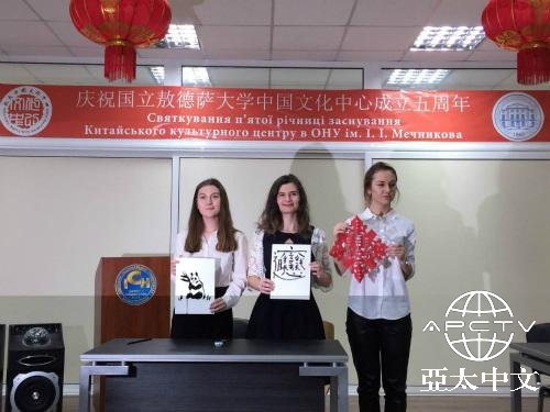 中国侨网敖德萨国立大学学生展示剪纸和书法作品。